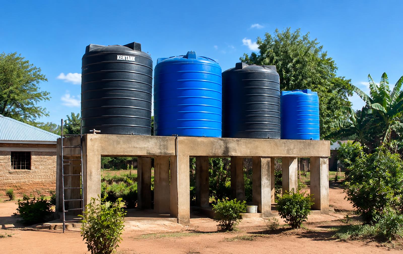 Large plastic water storage tanks on a raised stand at a Kenyan home